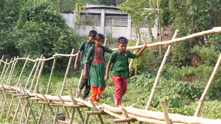 গ্রামীণ এলাকার শিশুরা বাঁশের সাঁকো দিয়ে নদী পার হচ্ছে