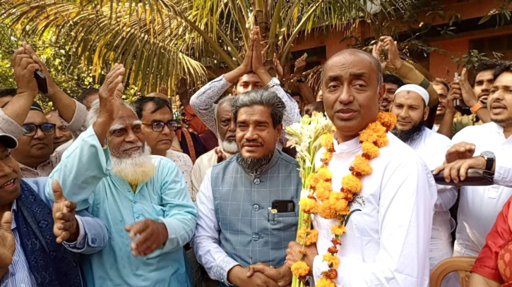 পরাজিত প্রার্থীকে ফুল দিয়ে একসঙ্গে কাজ করার প্রত্যয়